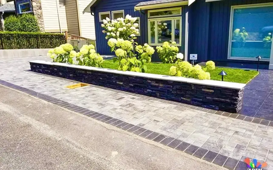 Paver apron and planted strip across the front of a house on an older residential street