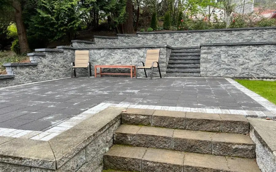 Terraced grey stone patio with wide steps on a steep back garden in central Seattle