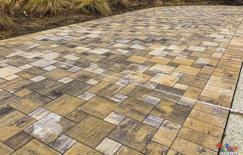 Close view of a paver patio in blended tan and grey tones laid in a random ashlar pattern