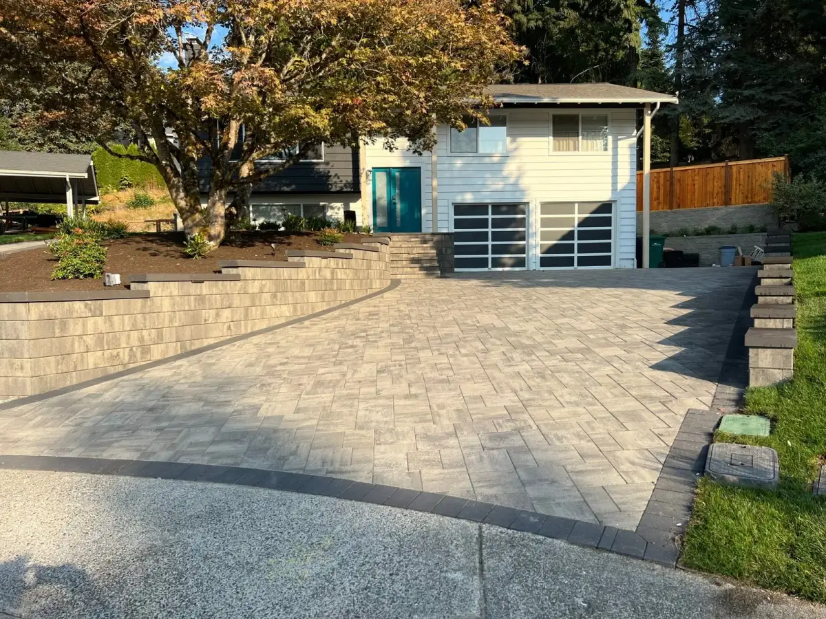 Wide paver driveway and turning apron in front of a garage on a mature Seattle-area lot