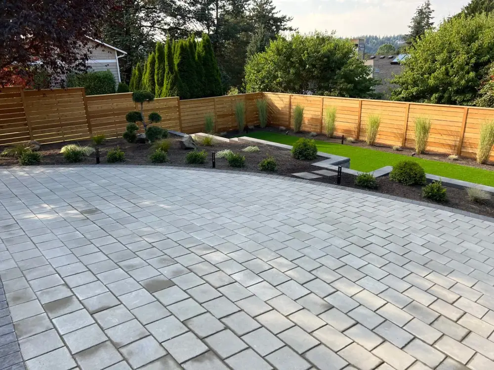 Large paver patio with artificial turf lawn, new planting beds and horizontal cedar fencing