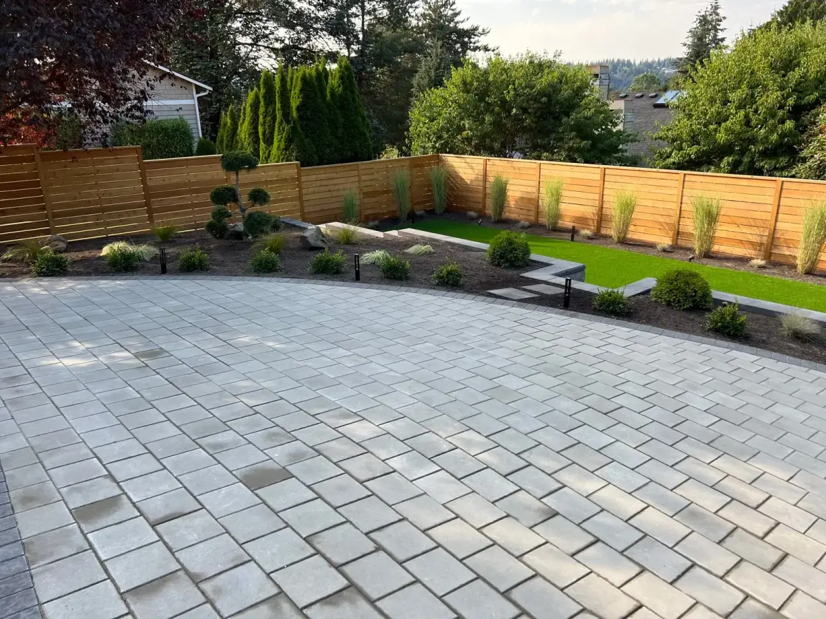 Large paver patio with artificial turf lawn, new planting beds and horizontal cedar fencing