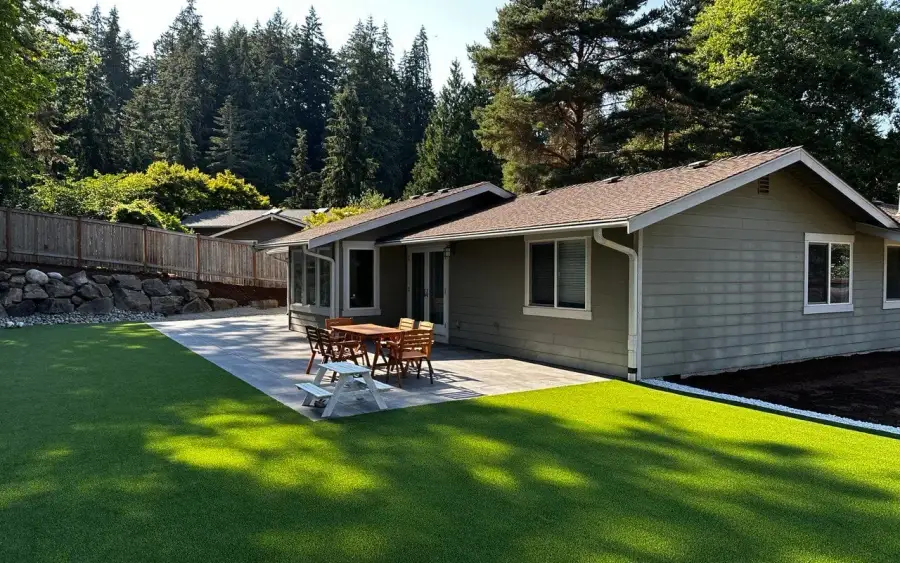 Artificial turf lawn and paved patio running the full width of a single-storey Magnolia house