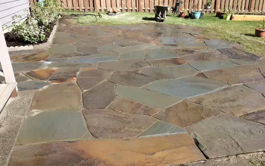Hand-fitted natural flagstone patio in a fenced back garden