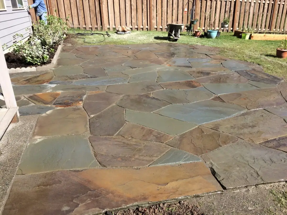 Hand-fitted natural flagstone patio in a fenced back garden