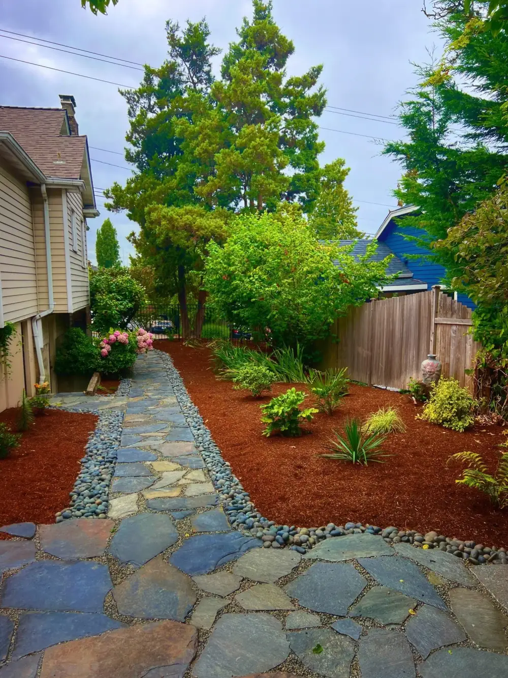 Flagstone stepping path with a river rock edge and fresh bark mulch beds