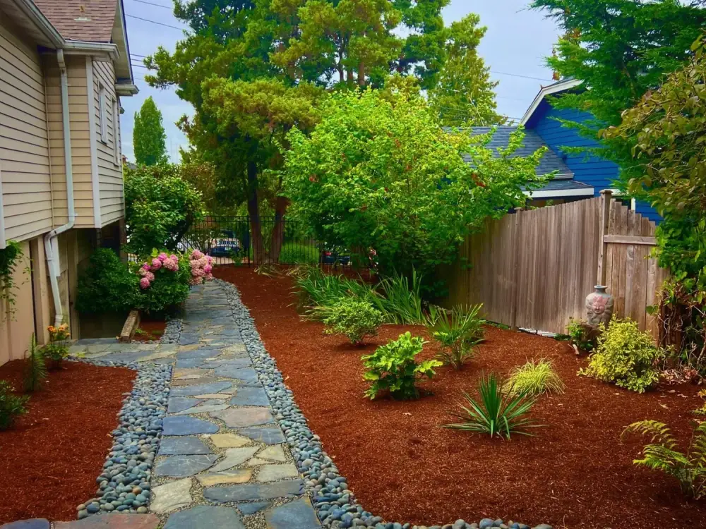 Flagstone stepping path with a river rock edge and fresh bark mulch beds